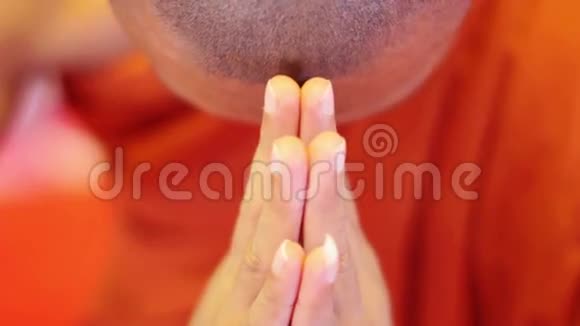 僧人身穿橘色长袍在寺庙内祈祷视频的预览图