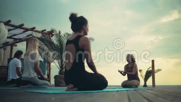 在海滩上练习瑜伽的女性团体视频的预览图