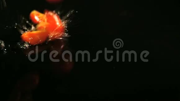 番茄落在黑色表面的水滴缓慢运动视频的预览图