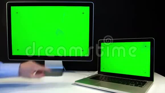 在笔记本电脑上工作并用绿色屏幕显示视频的预览图