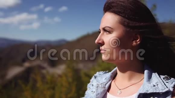 肖像一个美丽的女孩站在山上送一束美丽的花享受着气味视频的预览图