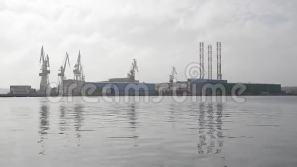 日落时船坞里的起重机亚得里亚海的港湾码头的起重钻机油台和集装箱起重机船舶港口工业视频的预览图