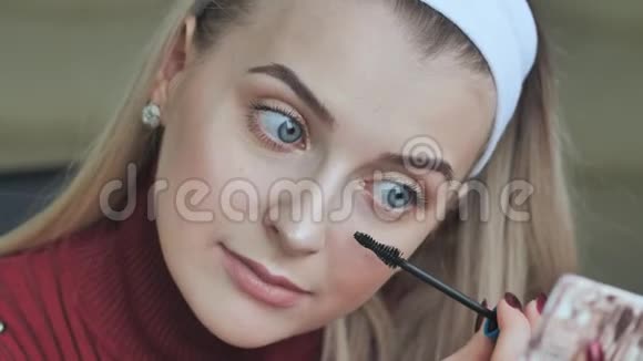 美丽的金发女孩画她的睫毛视频的预览图