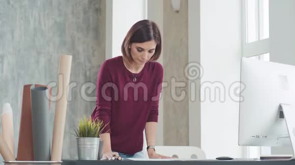 女人站在桌子前调整图纸视频的预览图