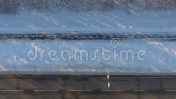 冬季人们在靠近城市道路的雪道上慢跑视频的预览图