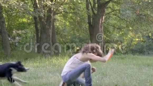 边境牧羊犬试图抓住一只飞盘跳过一个女孩的背部慢动作视频的预览图