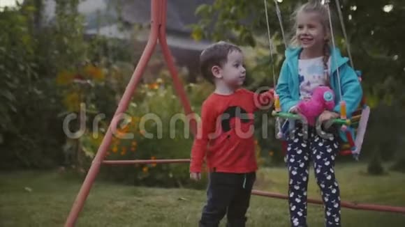 两个快乐的漂亮孩子牵着手在新鲜的空气中玩耍视频的预览图