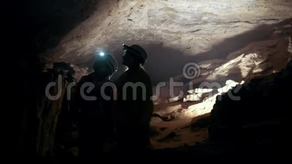 一群带手电筒的青少年走进一个黑暗的洞穴视频的预览图