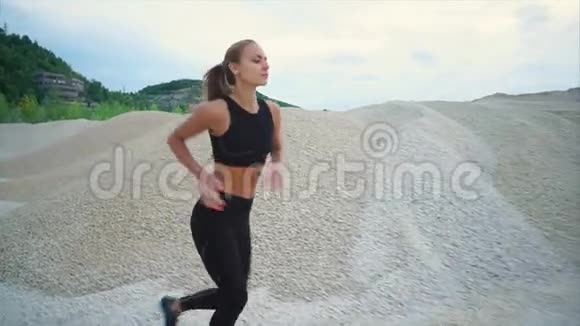 女孩在露天的砾石山上慢跑视频的预览图