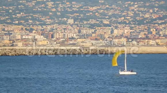 白色游艇黄帆浮在那不勒斯湾附近水运视频的预览图