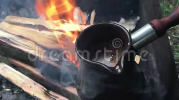 火鸡里的咖啡放在室外的柴火上视频的预览图