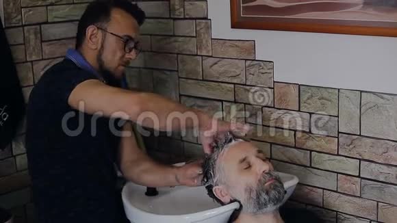 理发师清洗客户的头部视频的预览图
