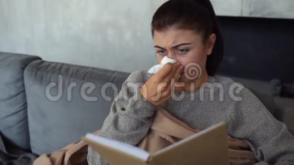 沮丧的生病的女士在看书和擦鼻子视频的预览图