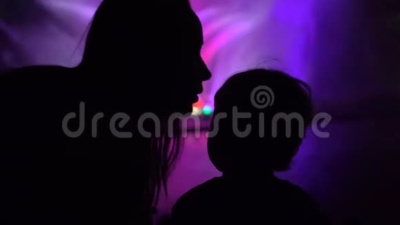 母亲和儿子看一场五颜六色的舞蹈喷泉表演女人吻她儿子视频的预览图