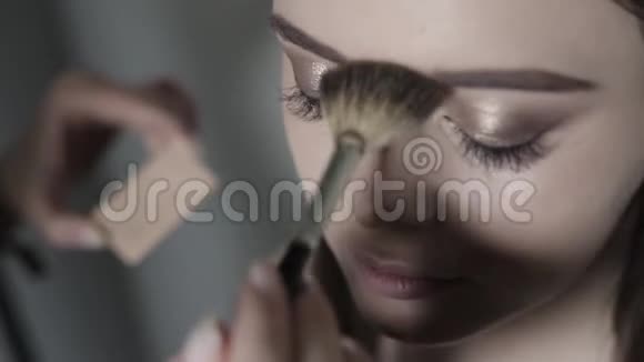 化妆师应用荧光笔年轻女孩做职业化妆视频的预览图