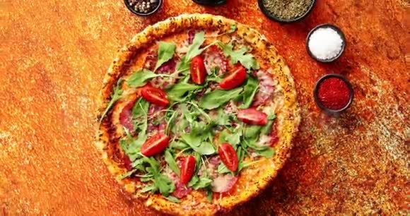 用香料草药和蔬菜在生锈的背景上烤披萨视频的预览图