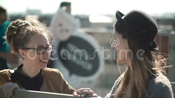 两个时髦的漂亮女人说话在明亮的日子里在一起设计师在外面讨论新项目视频的预览图