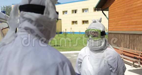 两名身穿埃博拉病毒防护制服的医生或护士站在救护车附近视频的预览图