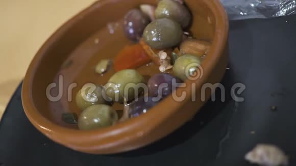女人手把罐头里的橄榄放进餐馆的瓷盘里视频的预览图