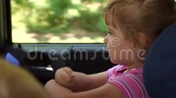 一个小女孩坐在汽车安全座椅上的肖像视频的预览图