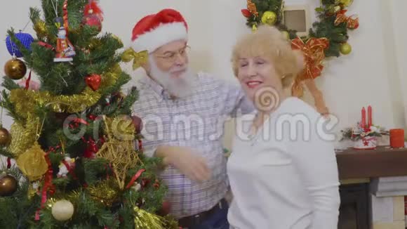 快乐的成熟夫妇装饰圣诞树视频的预览图