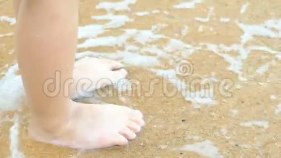 孩子的腿站在海滩上惊涛骇浪视频的预览图