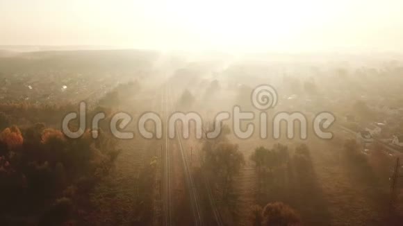 日出时铁路在雾中行驶无人驾驶飞机的视角视频的预览图