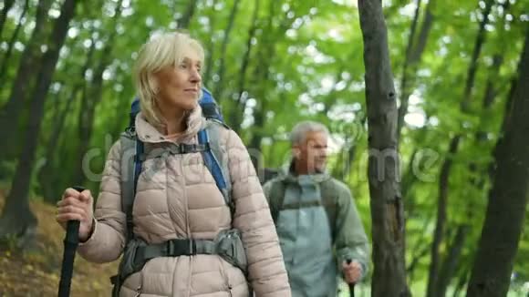积极的退休妇女与丈夫在树林里散步视频的预览图