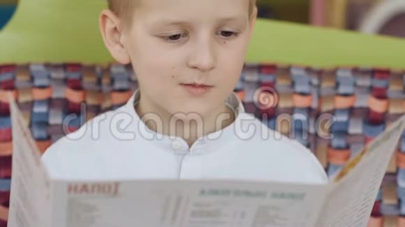英俊年轻开朗的男孩在咖啡馆里阅读菜单和思考视频的预览图
