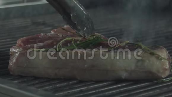 用厨房的火钳把牛肉排压下来然后煎视频的预览图