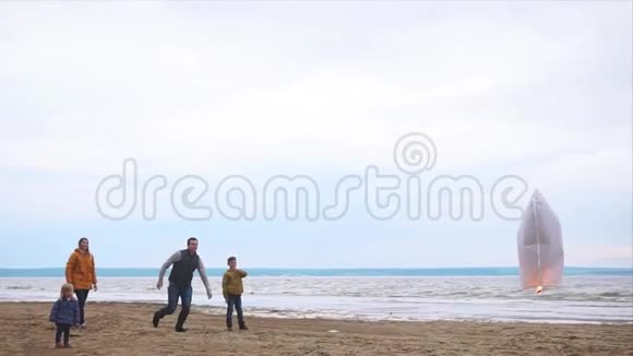 一个友好的家庭在海边爸爸追着一盏纸灯笼跑视频的预览图