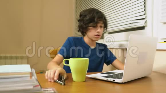 少年把茶倒在笔记本电脑上做作业在线学习4K特写视频的预览图