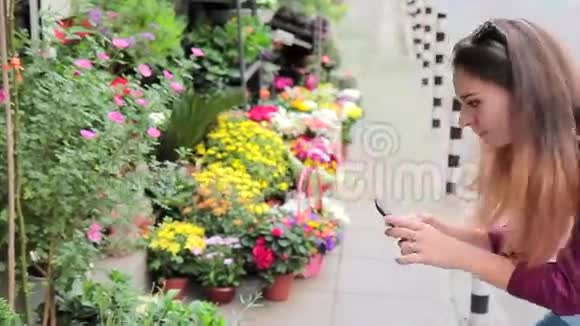 在欧洲街头的一家小花店里一位年轻女子正在为鲜花拍照视频的预览图