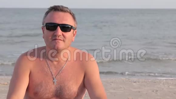 人们在度假时很开心摘下眼镜在海滩上晒日光浴视频的预览图