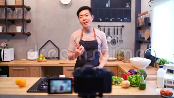 微笑亚洲男子在食品博客概念与水果和蔬菜在厨房视频的预览图