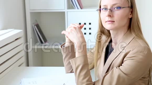 年轻漂亮的商务女性戴着眼镜和文件在工作场所的办公室工作视频的预览图