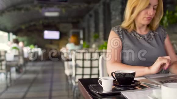 女商人在笔记本电脑咖啡馆工作视频的预览图