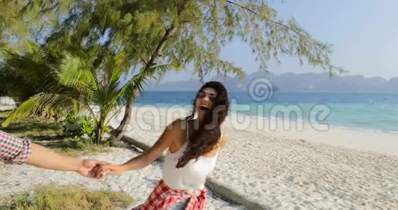 女孩带领男人下水情侣牵着手在沙滩上散步快乐的微笑游客在海上度假视频的预览图