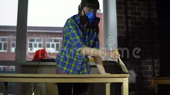 女木匠在车间用刷子从桌面上敲打木屑视频的预览图