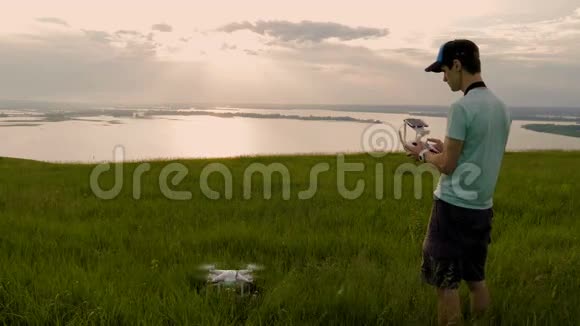一个年轻人在风景如画的背景下控制着一架无人机视频的预览图