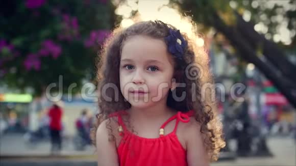 夹起来美丽的小女孩在公园里旋转微笑着库存录像视频的预览图