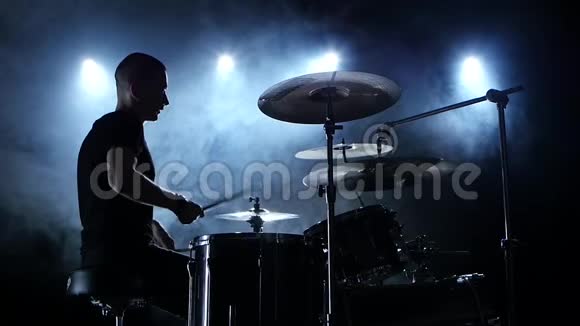 音乐家在鼓上演奏旋律黑烟背景侧视剪影慢动作视频的预览图