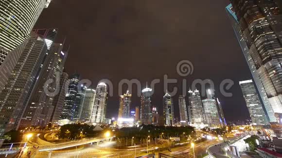 时间推移城市交通和步行的人在夜间剪影现代摩天大楼视频的预览图