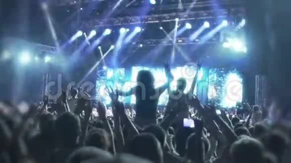 音乐迷群在发光二极管照明下跳舞音乐会视频的预览图