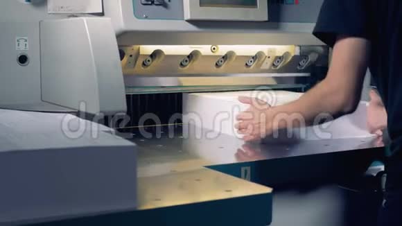 印刷厂工人操作切割机工人在排版中剪一叠纸视频的预览图