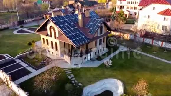 屋顶上的太阳能电池板在阳光明媚的春天从房子上方的无人机空中射击视频的预览图
