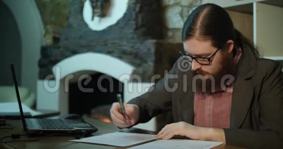 一个留着胡子的年轻人在壁炉附近签了字视频的预览图