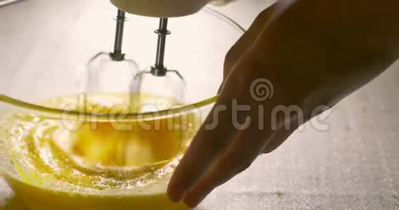 电动搅拌器将鸡蛋打在玻璃碗里烹饪特写视频的预览图