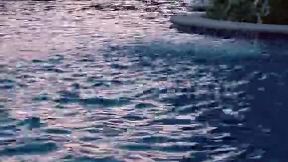 日落时在热带海岸豪华度假酒店的游泳池观看泉水喷泉喷射玛雅视频的预览图