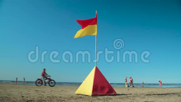 救生员安全红黄旗与人和自行车在海滩特写视频的预览图